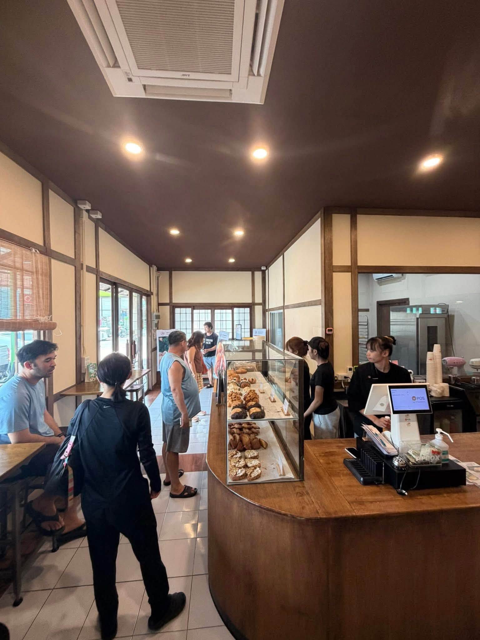 บรรยากาศภายในร้าน Minamoto มุมกว้าง เห็นตู้กระจกใส่ขนมและลูกค้า